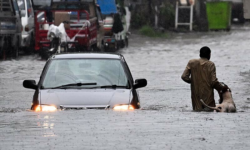 Flooded streets in Punjab with emergency vehicles in the background.