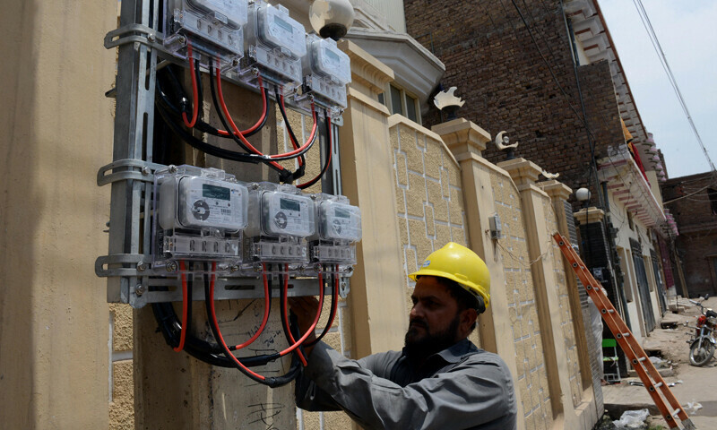 Technician installing an AMI smart meter in Rawalpindi.