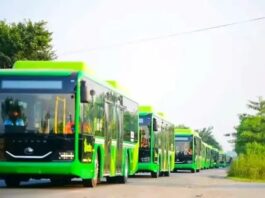 Modern Green Bus shelter in Punjab with electric bus and commuters