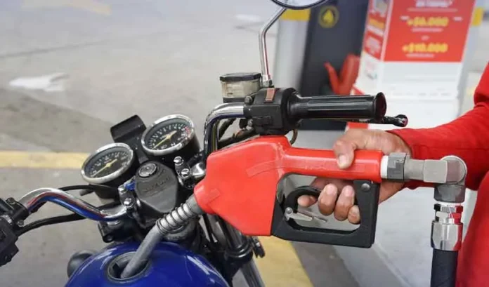 Motorcyclist and rickshaw driver at petrol pump getting fuel subsidy relief in Pakistan